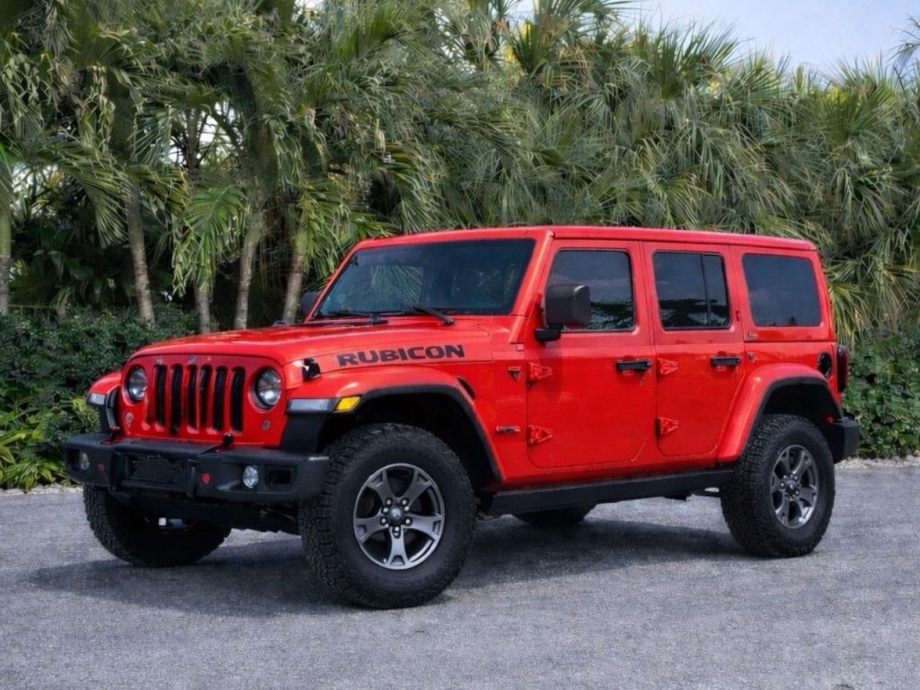 Red Jeep Wrangler Rubicon parked with palm trees in the background in the Florida Keys, ideal for island cruising, beach trips, and scenic drives.